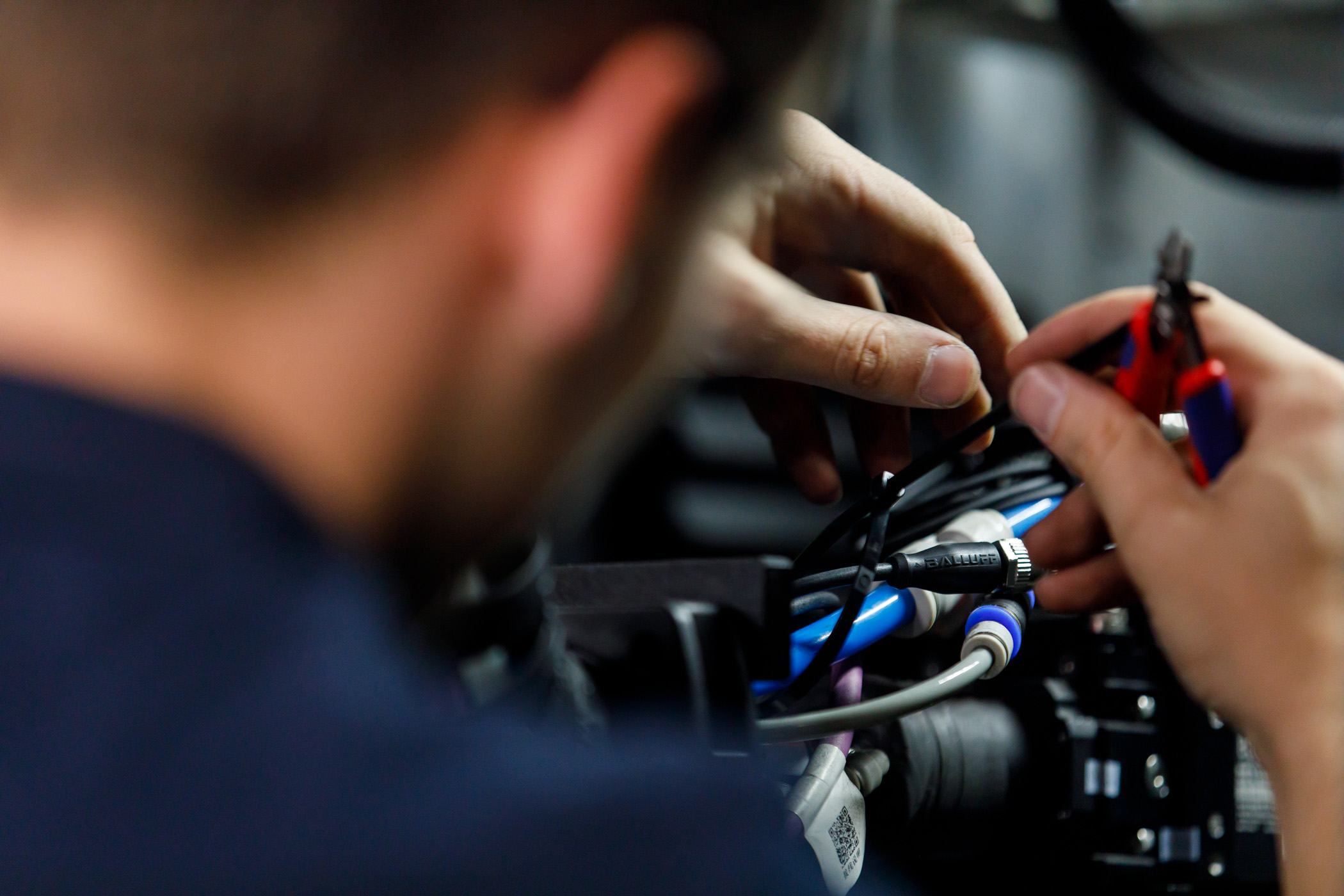 The mechanic installs a smart sensor on a machine part